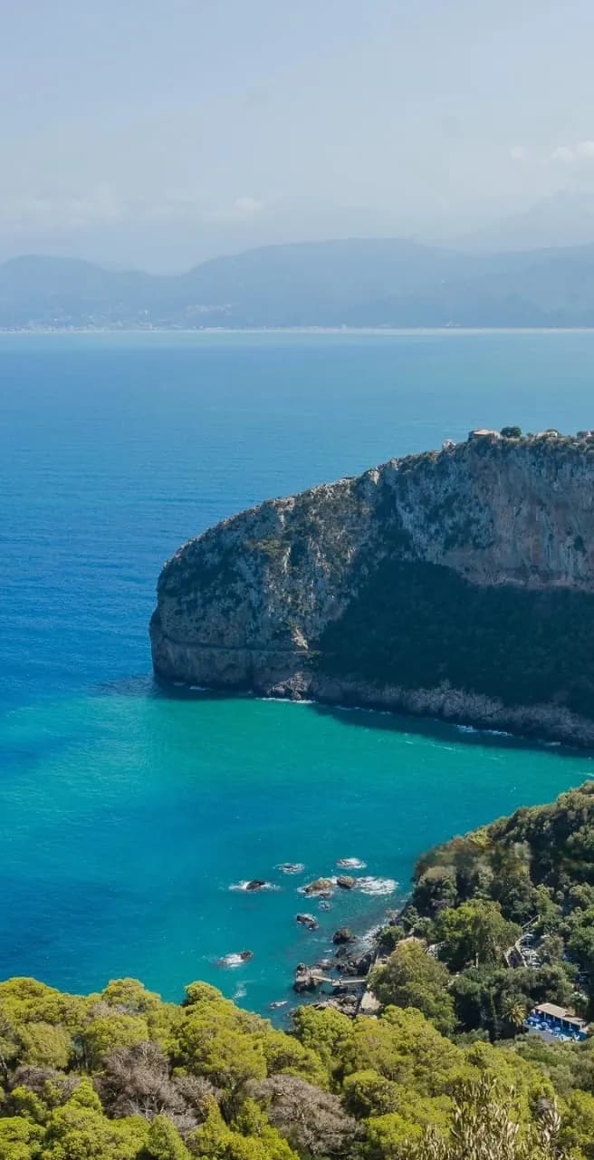 A wooded headland above a turquoise bay on the Béjaïa coast
