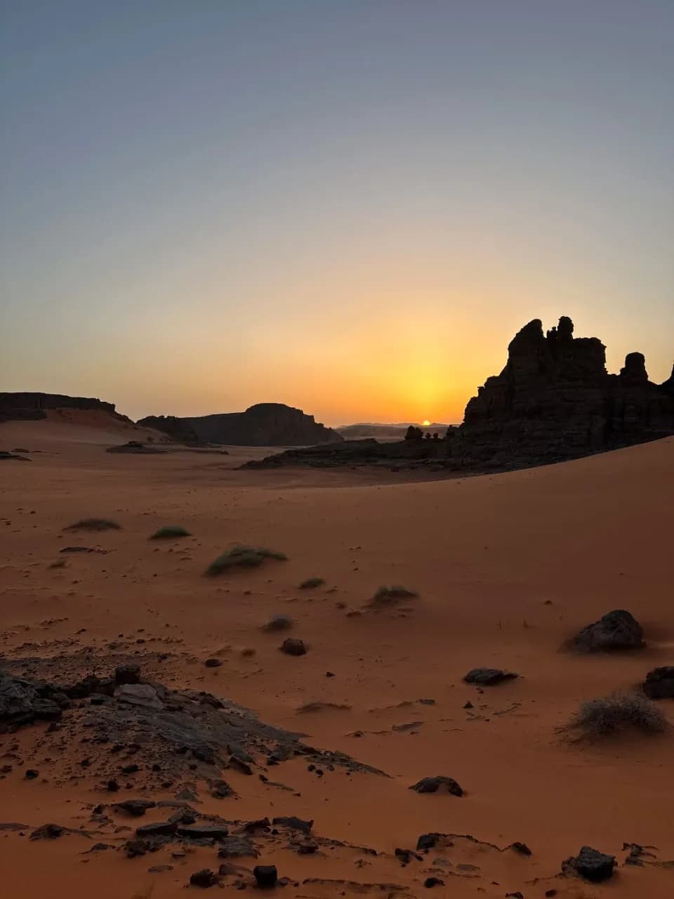 Sunset over red sand and rock towers in the Algerian Sahara